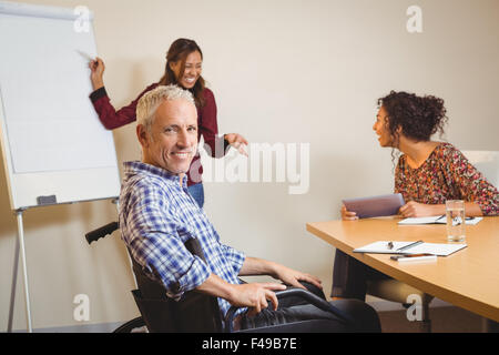 Geschäftsmann am Rollstuhl in Kreativbüro Stockfoto