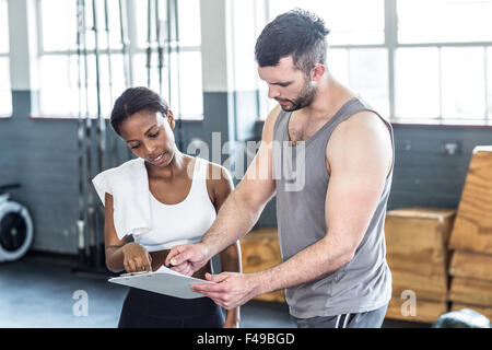 Frau, die ihre Leistung in Zwischenablage mit einem Trainer diskutieren Stockfoto