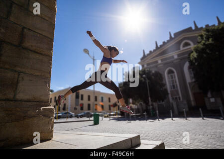 Sportliche Frau, die von der Treppe springen Stockfoto