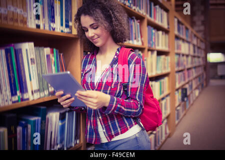 Hübsche Studentin in der Bibliothek mit tablet Stockfoto