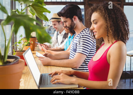 Glückliche Freunde Nutzung elektronischer Geräte Stockfoto