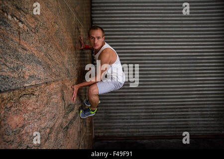 Extremsportler greifen an Wand Stockfoto