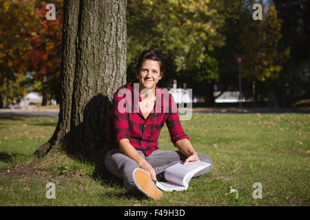 Studentinnen Schulbuch im Herbst tagsüber im freien Stockfoto