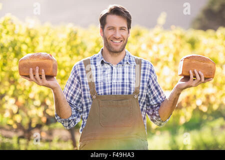 Lächelnde Bauern halten zwei leckere Brote Stockfoto