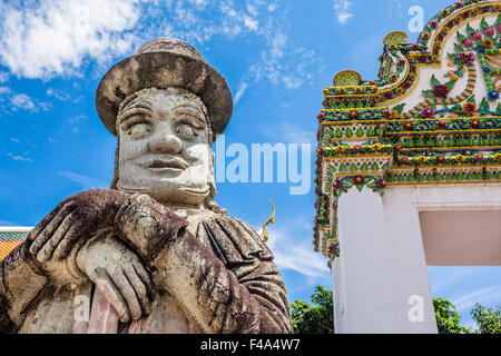 Thailand, Bangkok, Wat Po, warrier Statue mit Zylinderhut bewacht ein Tor in den buddhistischen Tempel Stockfoto