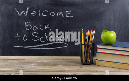 Alte hölzerne Desktop mit Grundschule liefert und Willkommen zurück zu Schule-Text auf Tafel für Studenten. Stockfoto