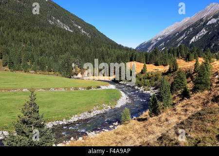 Der Fluss unter grünen Bergwiesen Stockfoto