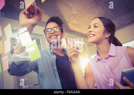 Geschäftsmann, während Kollege zeigte auf Kurznotizen schreiben Stockfoto