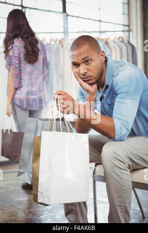 Gelangweilt Mann Einkaufstaschen in der mall Stockfoto