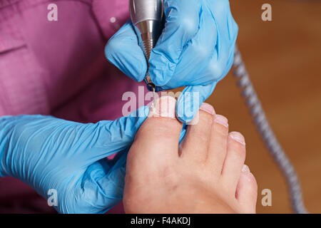 Meister Pediküre formt die Nägel und Nagelhaut. Hardware-Maniküre. Konzept-Körperpflege. Stockfoto