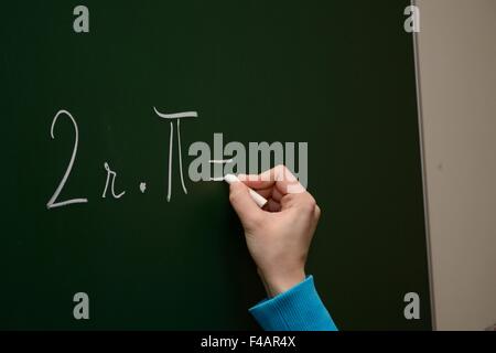 Student schreibt die Formel auf Tafel Stockfoto