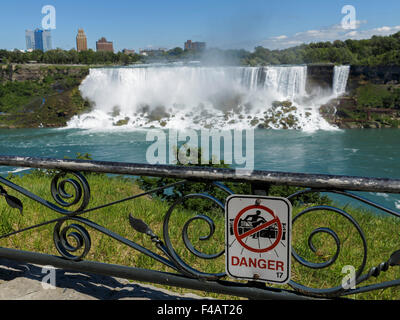 Gefahrenzeichen auf einen Metallzaun mit Blick auf die amerikanischen Wasserfälle, einer der Wasserfälle in Niagara Stockfoto