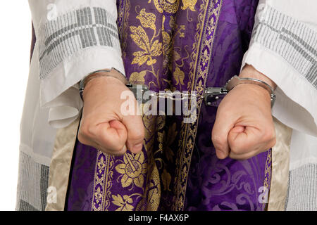 Missbrauch in der Kirche. Pfr. in Handschellen Stockfoto