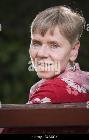 lächelnd auf der Bank Stockfoto