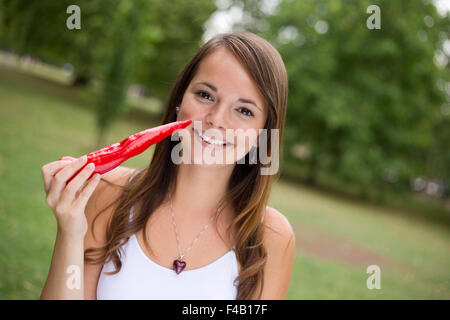 junge Frau hält eine rote Chilischote Stockfoto