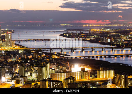 Japan, Osaka Bay Area. Anzeigen von Umeda Sky Building, Dämmerung. Gifu Brücke, beleuchtet, und Yodo Fluss und Akashi Kaikyo Brücke im Hintergrund. Stockfoto