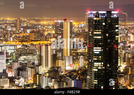 Japan, Osaka. Nacht Blick von Umeda Sky Building. Tall black Office Block und Blick auf die Stadt von mehreren Hochhäusern, hell beleuchtet. Stockfoto