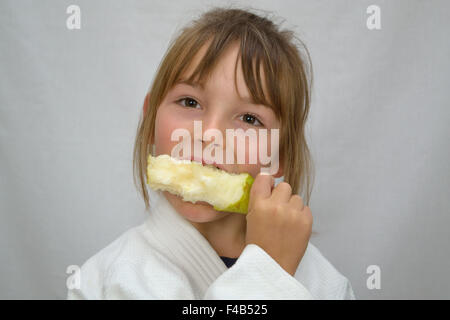 kleine Mädchen beißen Birne Stockfoto