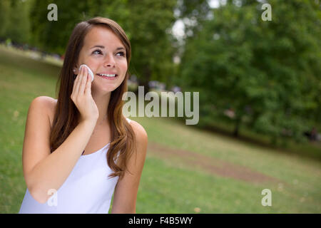 junge Frau, die ihr Gesicht mit Wattepads Gesicht reinigen Stockfoto