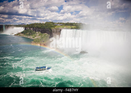 Regenbogen über dem Mädchen des Nebels Touristenboot am Niagara Falls Kanada Stockfoto