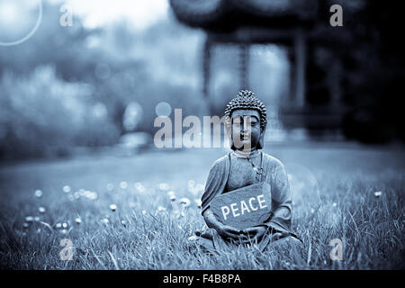 Das Wort Frieden mit Buddha-Statue Stockfoto