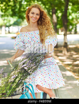 Schöne und glückliche junge Frau auf dem Fahrrad Stockfoto