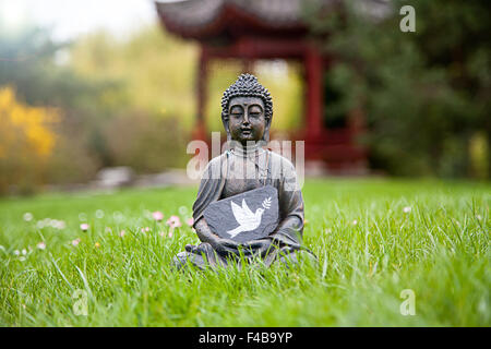 Friedenstaube mit Buddha-Statue Stockfoto