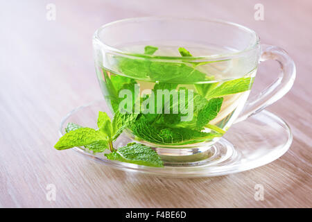 Pfefferminz-Tee in einer Glastasse auf dem Tisch Stockfoto
