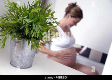 Schwangere Frau mit Bodylotion Stockfoto