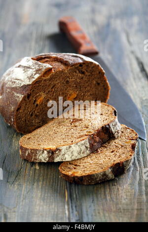 Roggenbrot mit getrockneten Aprikosen und ein Messer. Stockfoto