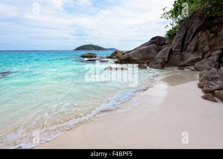 Wunderschöne Landschaft des blauen Meeres Sand und weißen Wellen am kleinen Strand in der Nähe der Felsen im Sommer auf der Insel Koh Miang Stockfoto