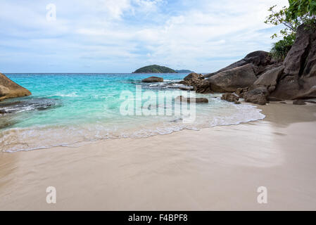 Wunderschöne Landschaft des blauen Meeres Sand und weißen Wellen am kleinen Strand in der Nähe der Felsen im Sommer auf der Insel Koh Miang Stockfoto