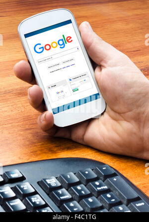 Barcelona, Spanien - 4. September 2015: männliche Hand, die auf Smartphones mit Google Websuche-Homepage auf dem Bildschirm (neue Google l Stockfoto