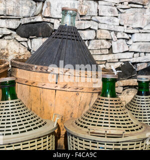 Korbflaschen Wein in ein Steinkeller. Stockfoto