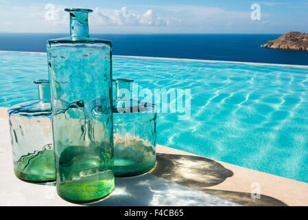 dekorative Glasflaschen neben einem pool Stockfoto