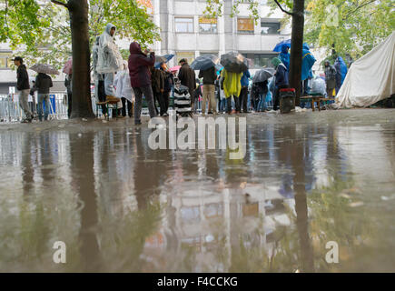 Berlin, Deutschland. 16. Oktober 2015. Flüchtlinge warten im Regen draußen das Landesamt für Gesundheit und Soziales (LaGeSo), in Berlin, Deutschland, 16. Oktober 2015 registriert werden. Foto: PAUL ZINKEN/DPA/Alamy Live-Nachrichten Stockfoto