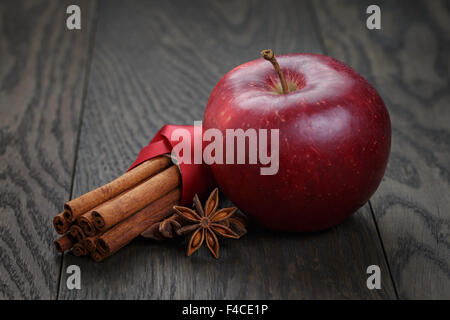 roter Apfel mit Zimtstangen und Anis Stockfoto