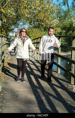 Paar laufen über eine Holzbrücke Salisbury Wiltshire Stockfoto