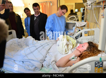 Jena, Deutschland. 16. Oktober 2015. Mutter der Vierlinge Oltjana Koci (r) mit einem ihrer Neugeborenen und ihren Vater Vebi Keta (3.f.r.) am Klinikum Universitaetsklinikum in Jena, Deutschland, 16. Oktober 2015. Eine Flüchtling Frau aus Albanien hat Vierlinge zur Welt gebracht. In der 32. Woche der Schwangerschaft wurden die drei Mädchen und ein Junge per Kaiserschnitt morgens geliefert. Mutter, Vater und Kinder sind wohlauf. Foto: MARTIN SCHUTT/DPA/Alamy Live-Nachrichten Stockfoto