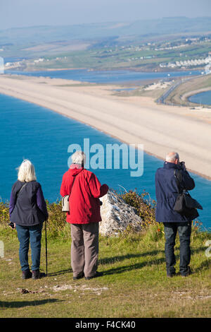 Besucher, die im Oktober über die Bank und die Fleet Lagoon in Portland, Weymouth, Dorset, Großbritannien, blicken Stockfoto