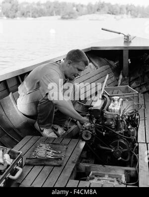 Mann arbeitet am Motor in einem Boot. Stockfoto