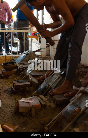 Junge Handwerker Stanzen Gold mit einem hammer Stockfoto