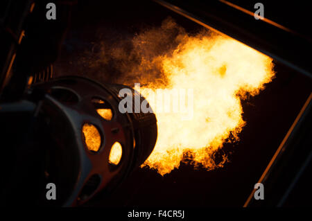 Flammen in der Nacht zu einem Heißluftballon erwärmen. Stockfoto