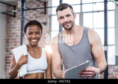 Frau, die ihre Leistung in Zwischenablage mit einem Trainer diskutieren Stockfoto