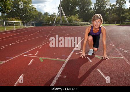 Nette Frau sieht es sportlich auf einem Stadion Stockfoto