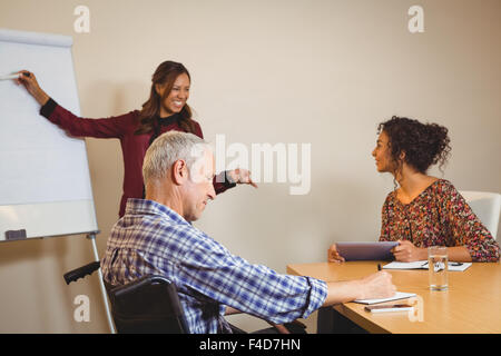 Geschäftsmann am Rollstuhl in Buch schreiben Stockfoto