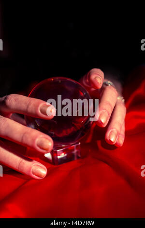 Händen der Wahrsagerin mit roten Kristallkugel beschnitten Stockfoto