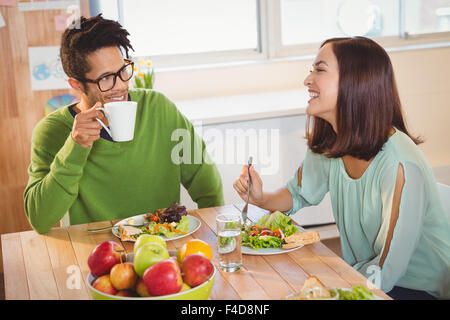 Geschäftsleute mit Frühstück im Kreativbüro Stockfoto