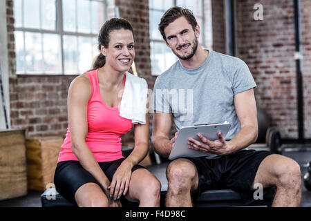 Lächelnde Frau diskutieren mit personal trainer Stockfoto