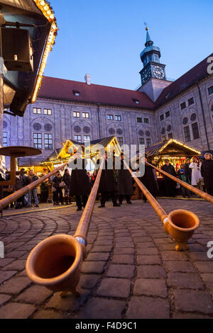 Das alpine Weihnachtsdorf im Kaiserhof der Residenz, das Schloss der Bayerischen Könige. Konzert mit Alphorn (Alphorn). München, Bayern, Deutschland. Stockfoto